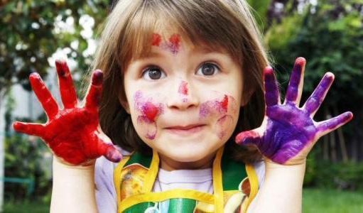 玩彩画的小女孩，满脸和双手沾满颜料